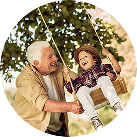 grandfather pushing his grandson on a swing